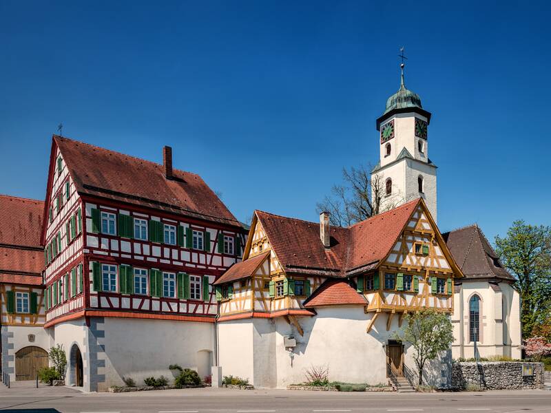 Kirche und Fachwerkhaus vor blauem Himmel