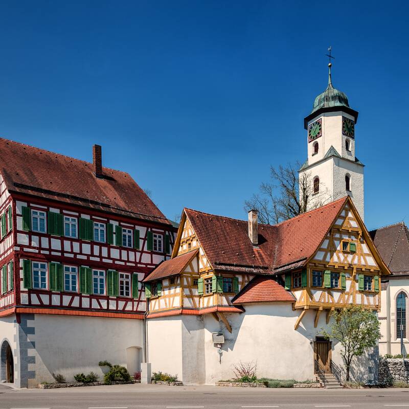 Kirche und Fachwerkhaus vor blauem Himmel