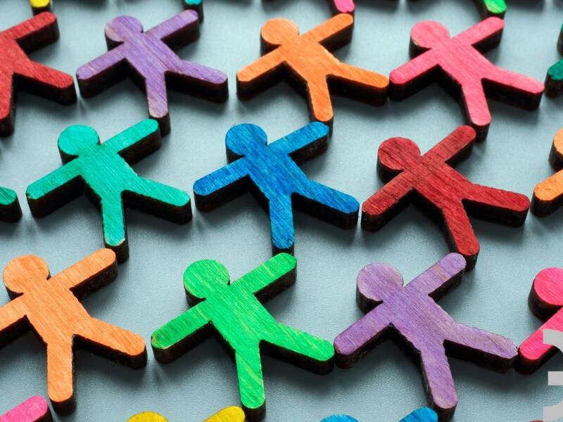 Bunte Holfiguren die gemeinsam zusammenstehen